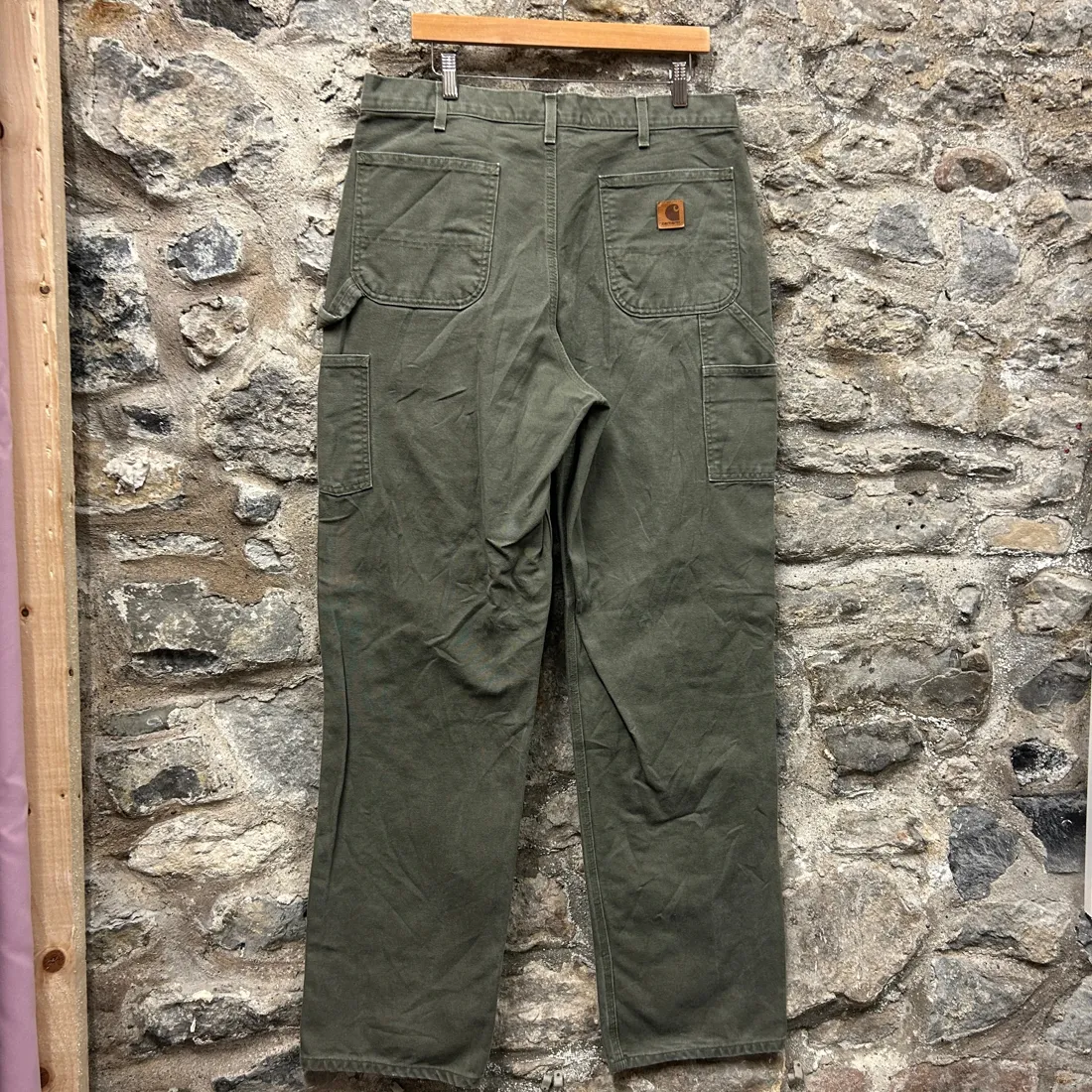 Carhartt label on army green canvas work pants